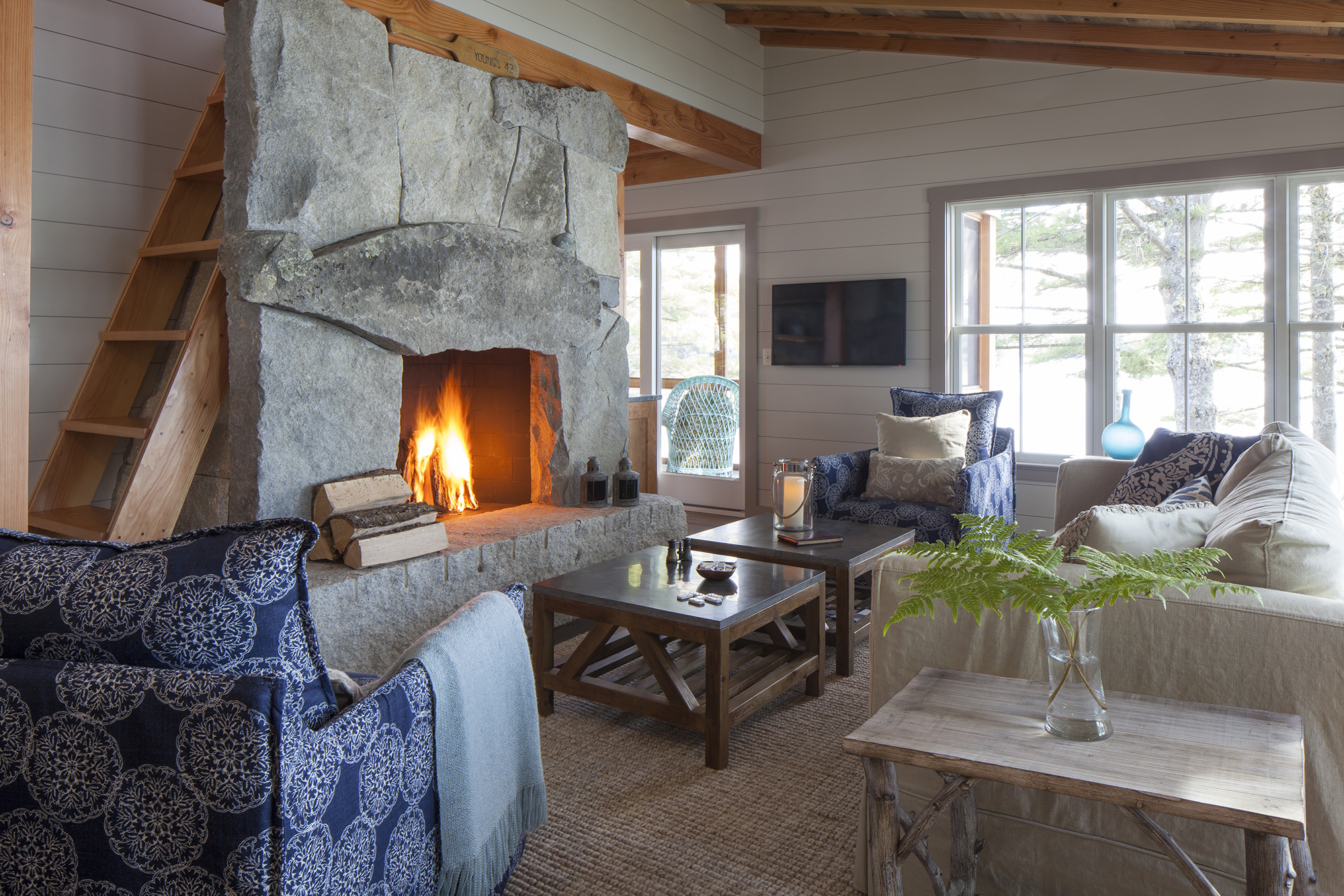 Cozy living space with a large stone fireplace at the Cross Point Cottages