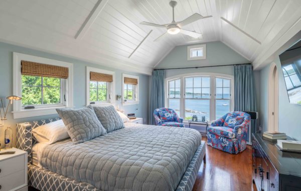 Bedroom with wood paneled arched ceilings and view of coast