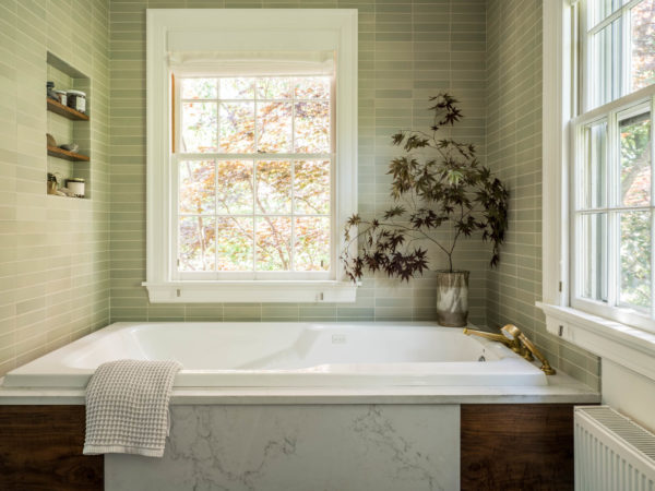 Tub with marble and wood siding and gold faucet