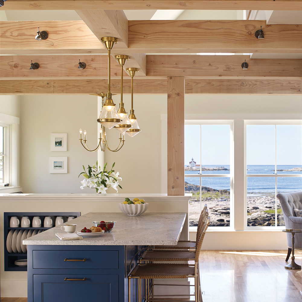 The gold details coupled with the wooden beams add a welcoming touch to this kitchen and living space.