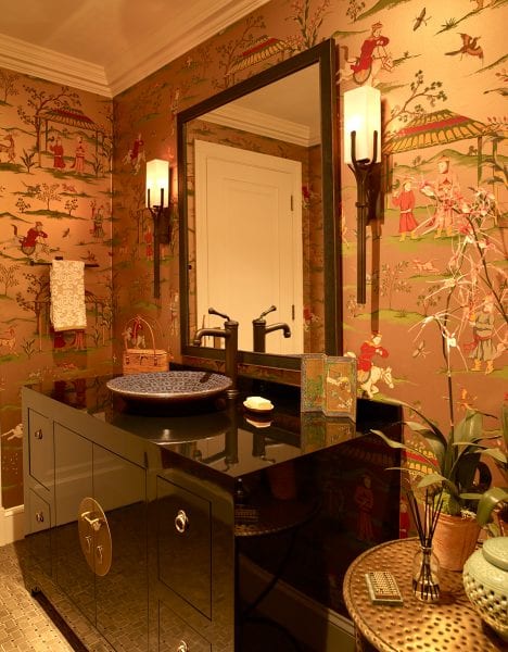 Japanese inspired bathroom with unique wallpaper, sconces, vanity, and sink.