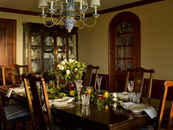 Large formal dining room with large china cabinet, built-in fine china cabinet, elegant chandelier, and spacious dining table.