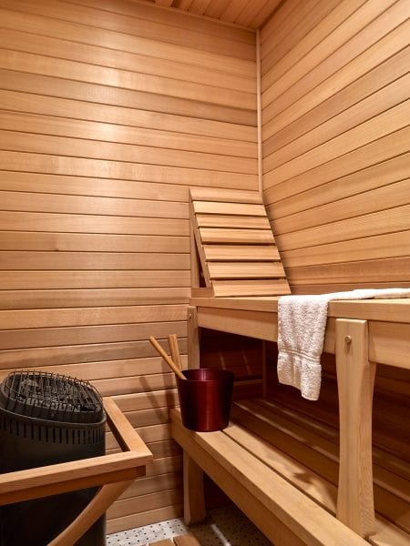 A sauna with bench and backrest for comfort.