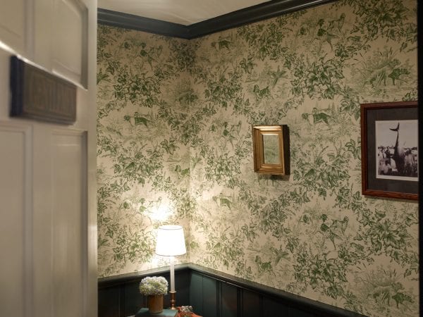 Wallpapered room with green trim and moldings