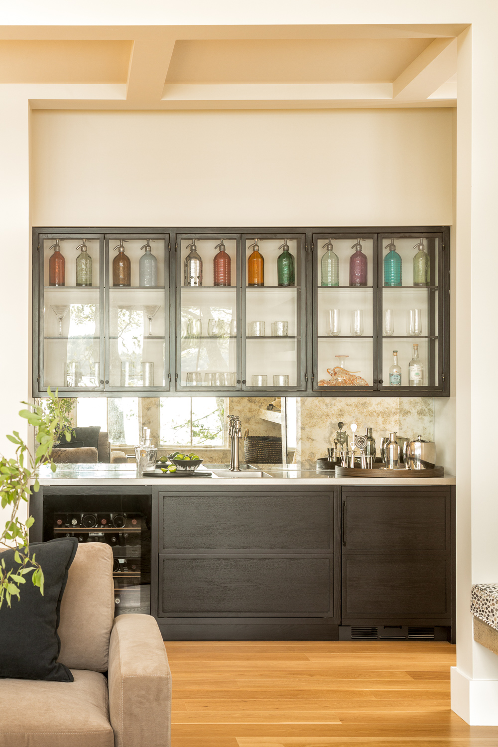 View of bar with overhead glass cabinets