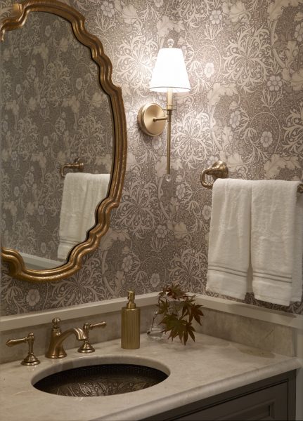Gold accents and floral wallpaper in powder room