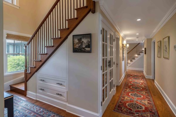 Hallway with sconces and view of stairways