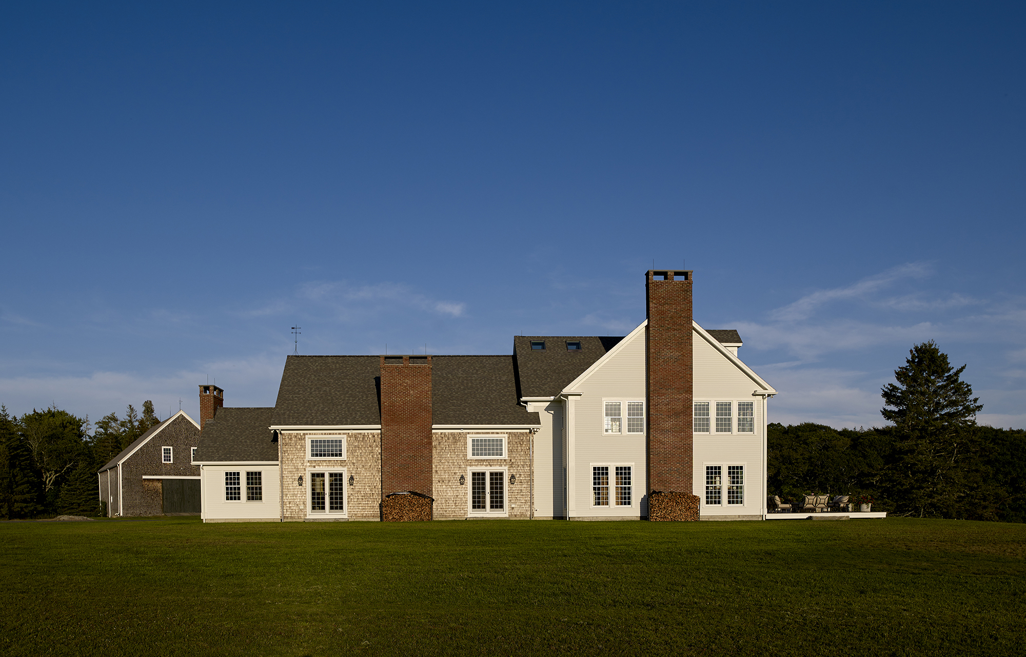 View of the home from the field showing three large chimneys