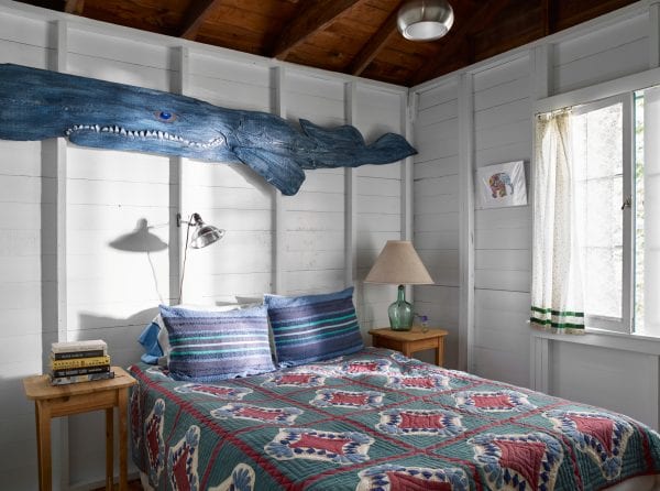 Whale decor above quilted bed
