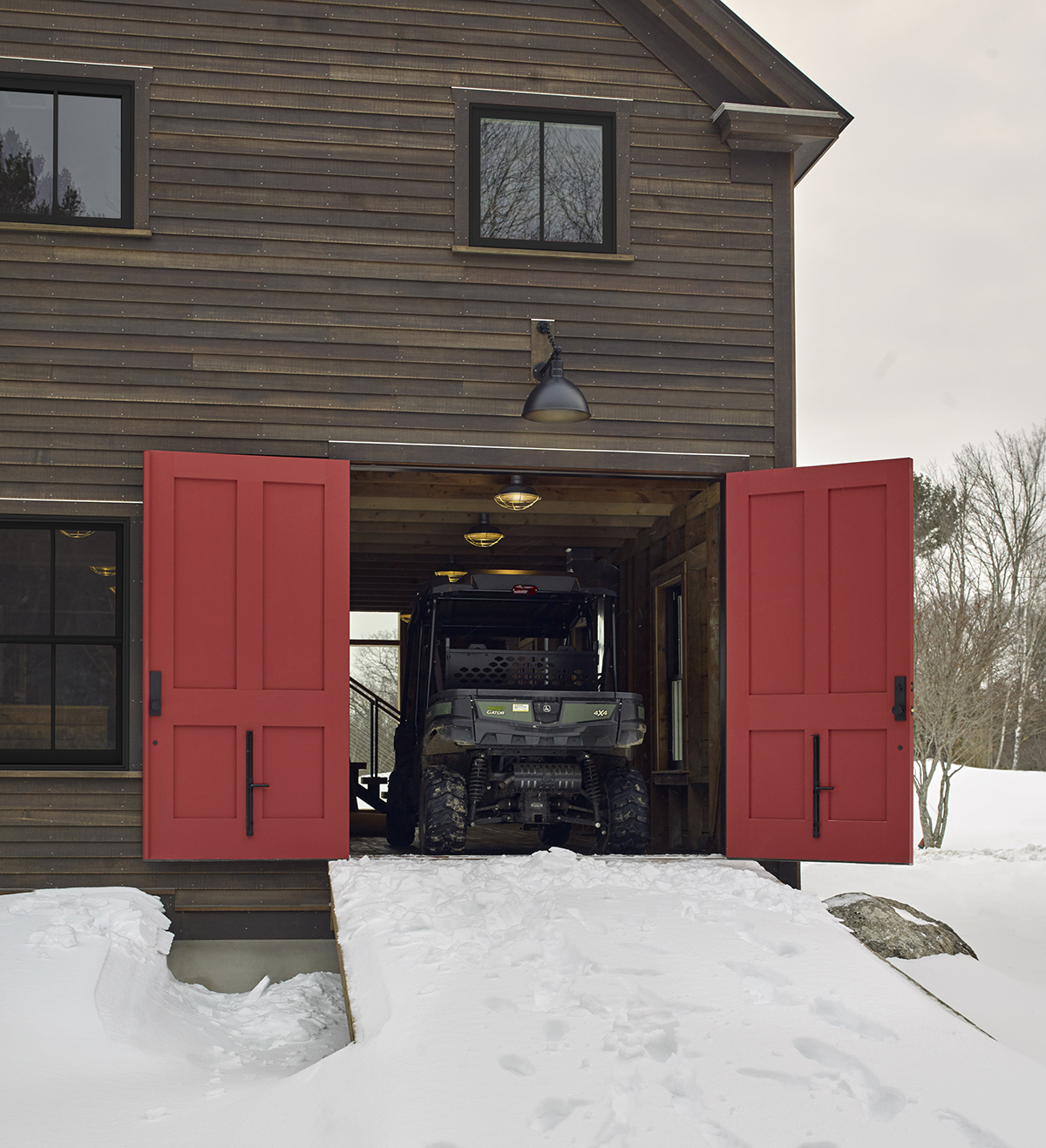 The cozy barn-style home has large doors for storing toys and staying out of the snow.