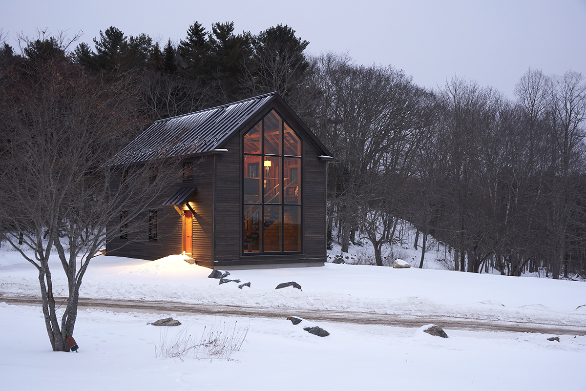 The approach to the cozy barn-style retreat with large picture windows