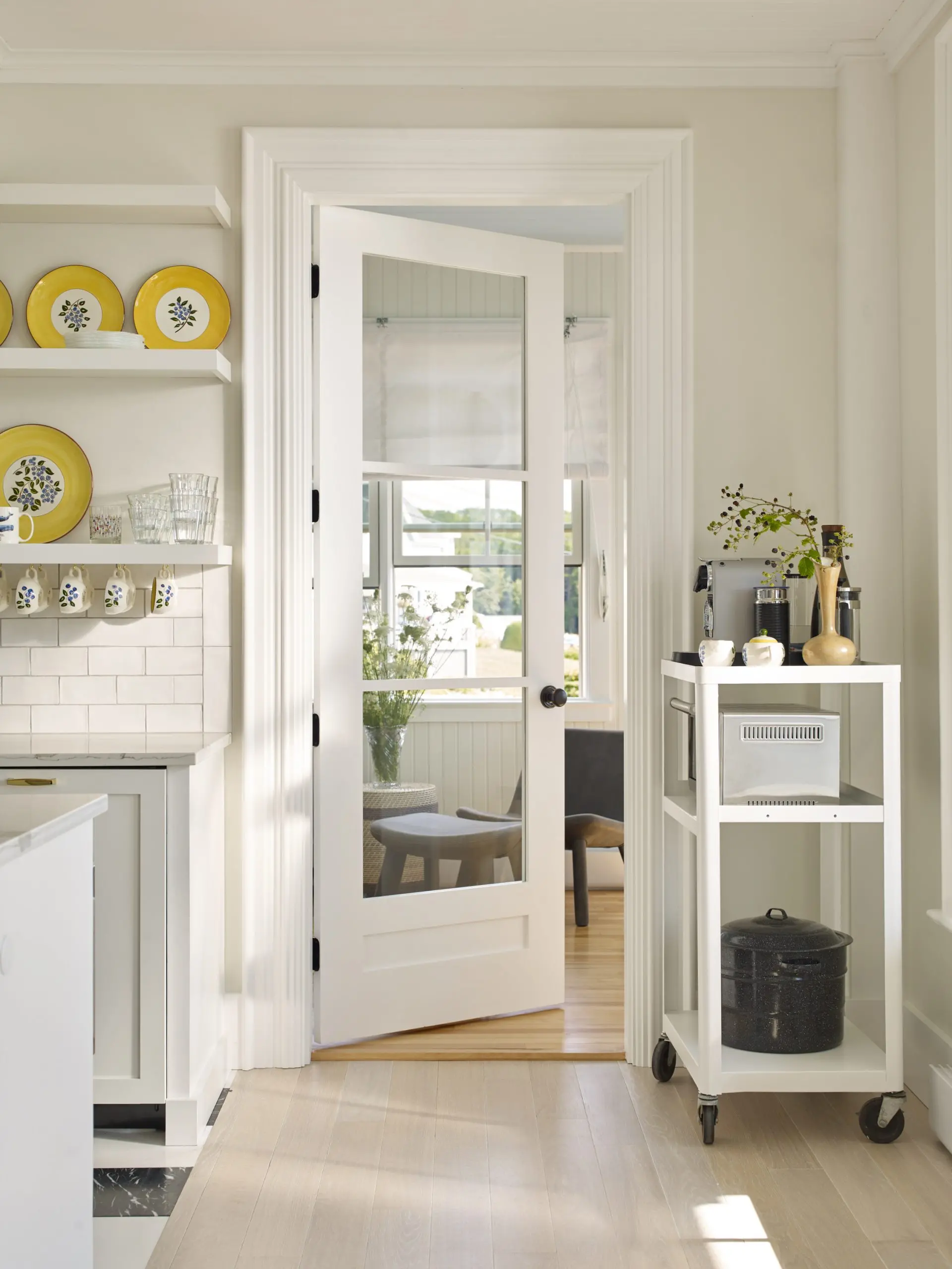 Bright inviting kitchen featuring a glass kitchen door leading to an inviting sitting area.