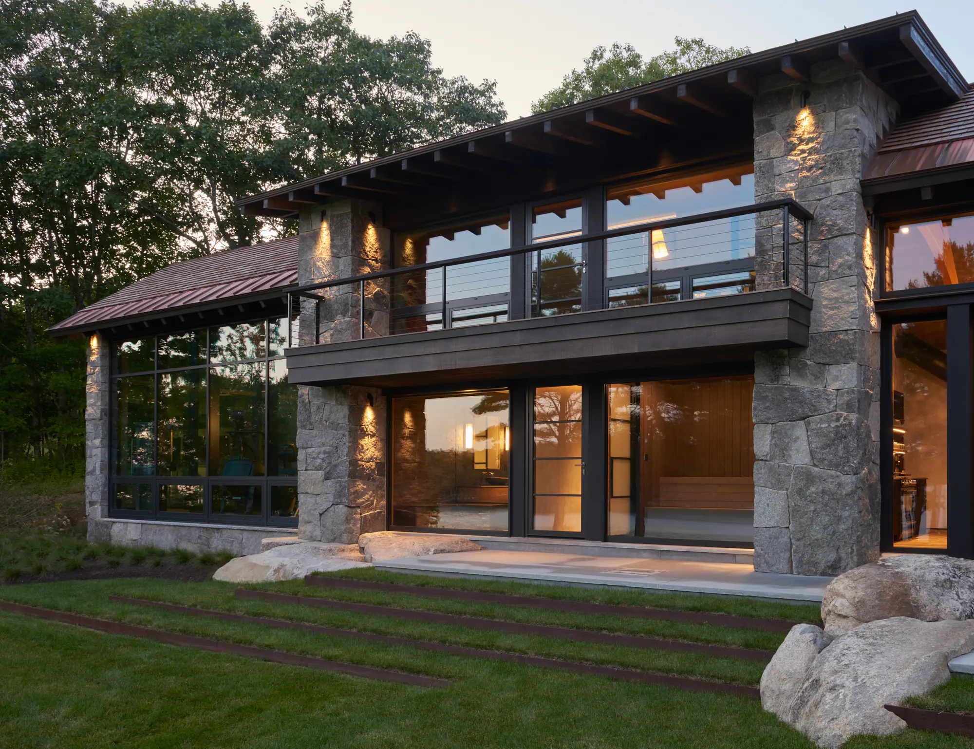 Large stone columns flank the entry and second floor deck
