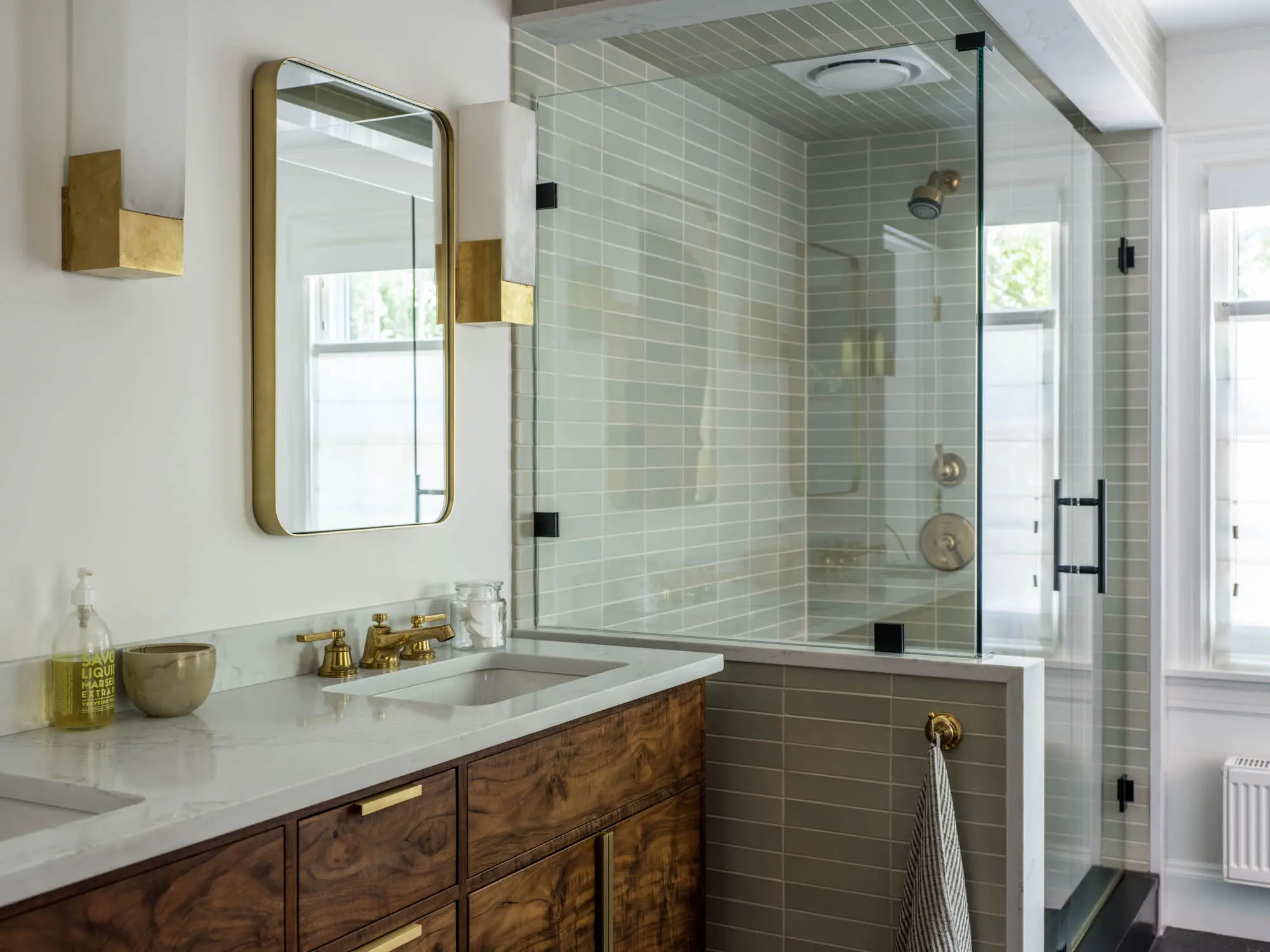 Custom cabinets with gold detail and matching mirror and light fixtures